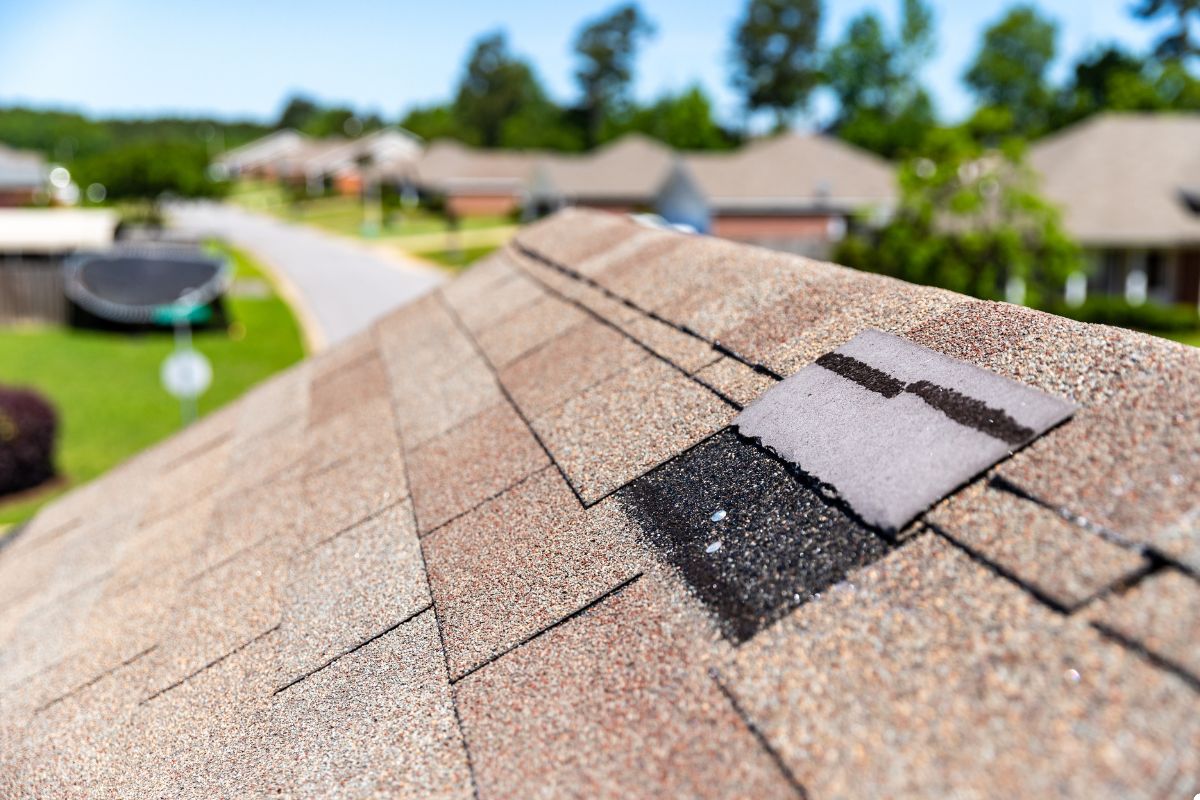 A roof with a small piece of paper resting on its surface, surrounded by a clear blue sky.